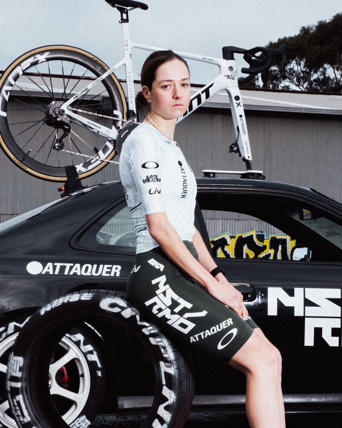 NSTRMO rider seated on the team car, bike on the roof