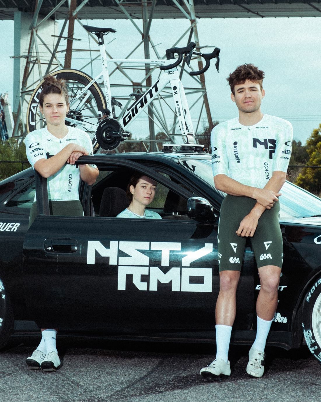 Two NSTRMO riders and the driver beside the open car door