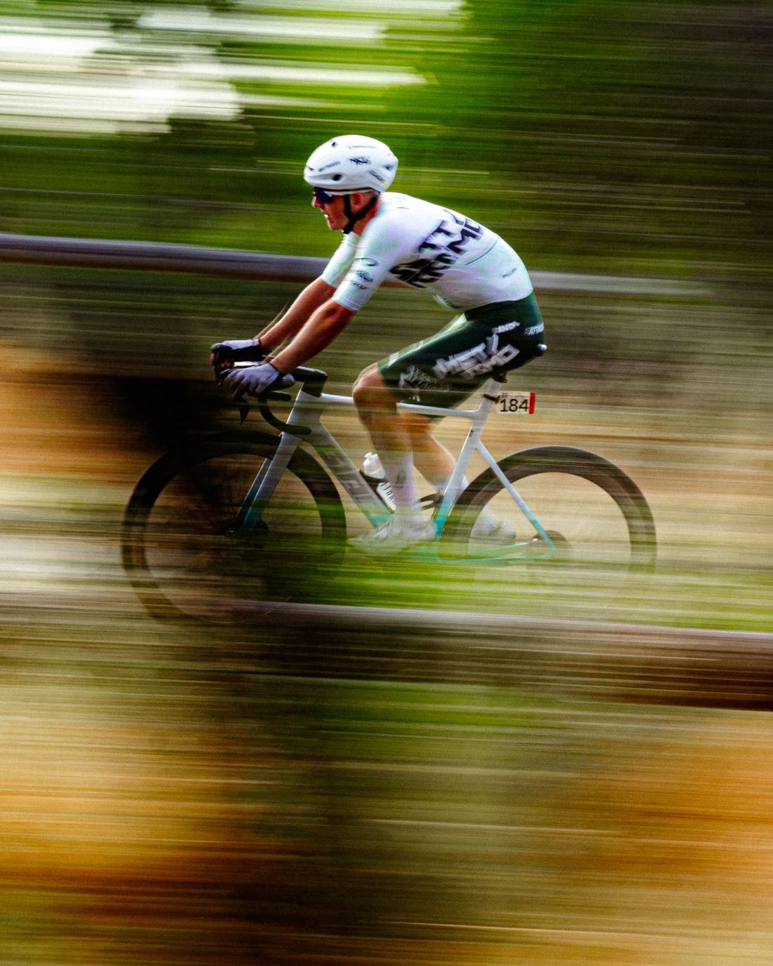 NSTRMO rider on a white bike, blurred surrounds