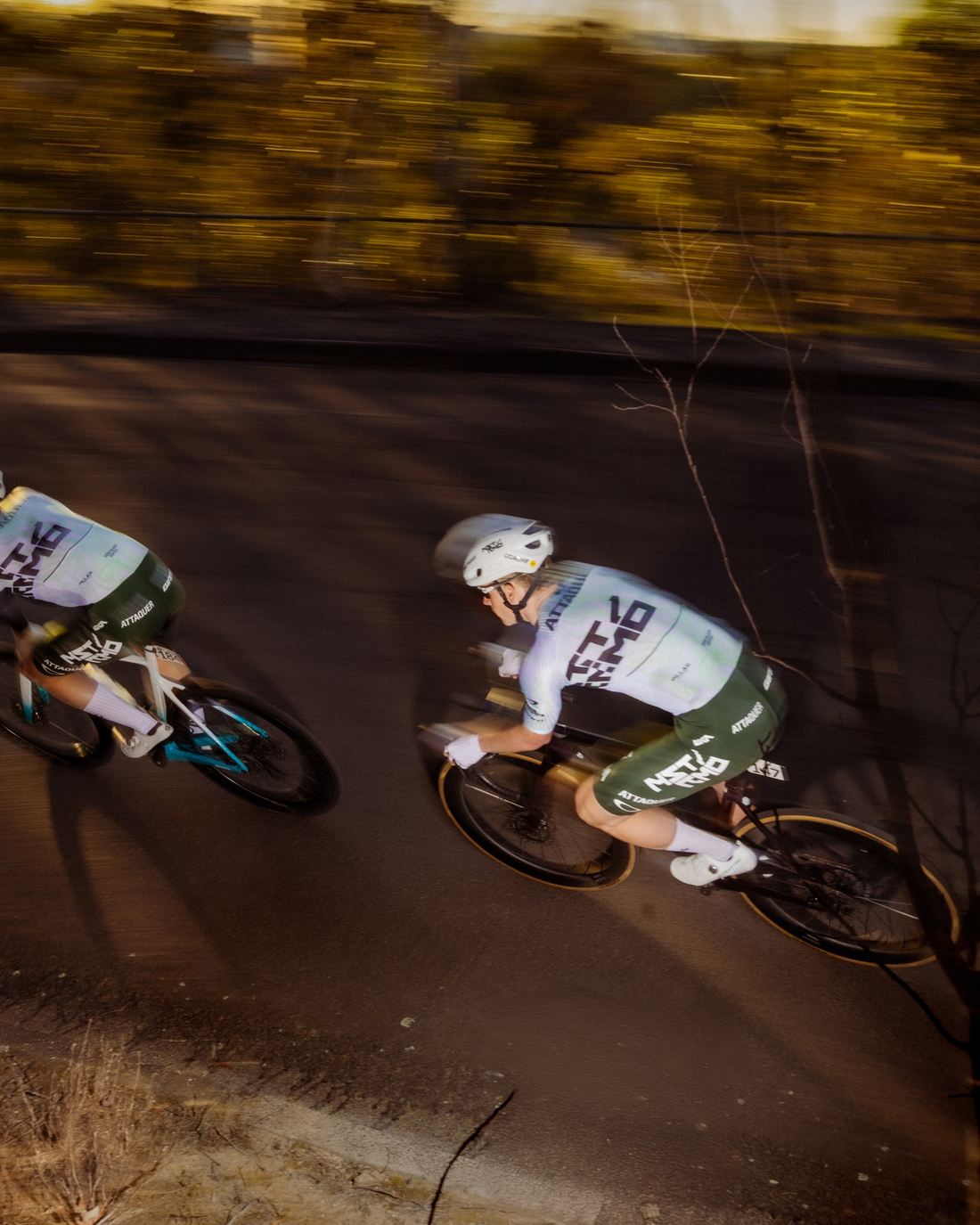 Two NSTRMO riders cornering in golden light