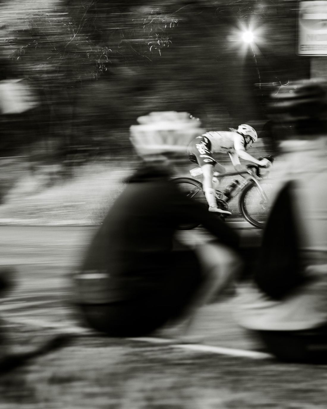 NSTRMO rider at speed past the bunch, black and white